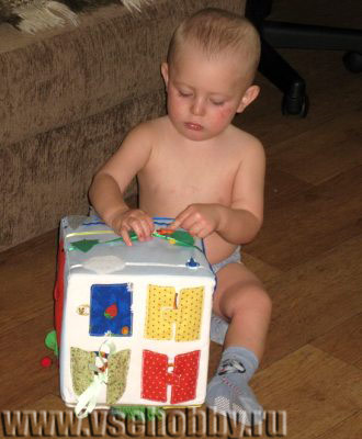 малыш играет с развивающим кубиком ручной функционировы